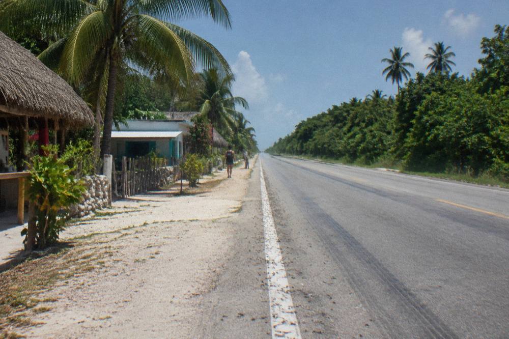 Empty coastal highway running south beside dense green jungle