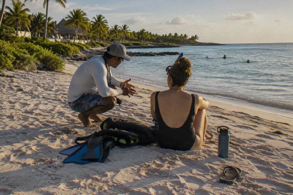 A private guide briefing one snorkeler on the sand before entering the water at Akumal Bay